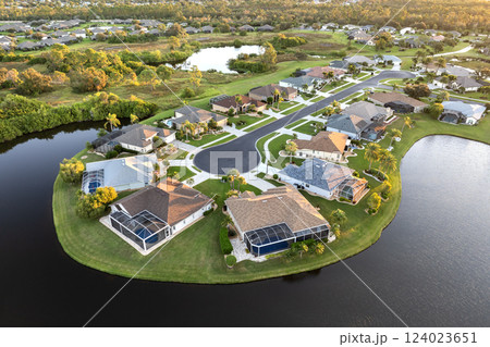 Low-density private homes at sunset. Rural street cul-de-sac dead end in residential suburbs with upscale suburban houses outside of Sarasota, Florida Low-density private homes at sunset. Rural street cul-de-sac dead end in residential suburbs with upscale suburban houses outside of Sarasota, Florida 124023651