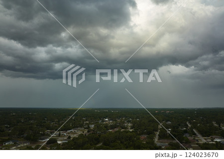 Landscape of dark ominous clouds forming on stormy sky before heavy thunderstorm over rural town area 124023670