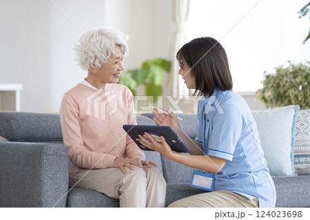 シニア女性とタブレットを持った介護スタッフ 124023698