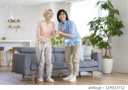 立ち上がるシニア女性をサポートする介護スタッフ 124023712