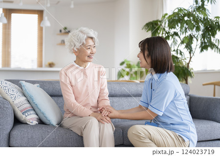 笑顔で向き合うシニア女性と介護スタッフ 笑顔で向き合うシニア女性と介護スタッフ 124023719