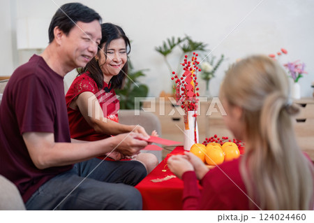 Celebrating chinese new year with family granddaughter and grandparents sharing traditions at home 124024460