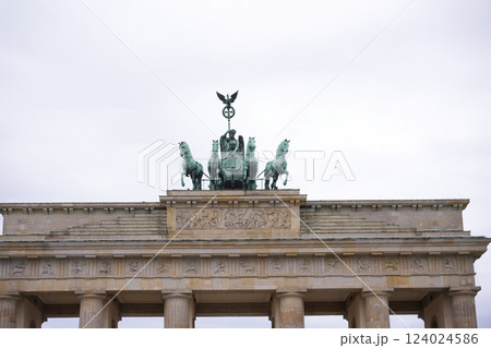 There is a statue of a horsedrawn carriage placed on top of a building There is a statue of a horsedrawn carriage placed on top of a building 124024586
