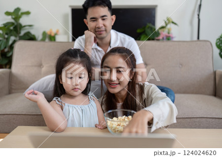Family under a blanket, sharing a fun movie moment 124024620