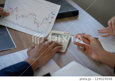 Finance and Analysis. A close-up of hands analyzing financial documents and using a calculator to assess data. Finance and Analysis. A close-up of hands analyzing financial documents and using a calculator to assess data. 124024648