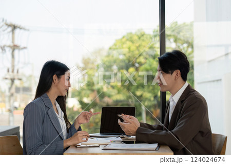 Collaboration in planning. Two professionals discussing project strategies in a modern workspace. 124024674