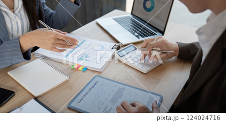 Team members analyzing financial data and discussing project management strategies in a collaborative workspace. Team members analyzing financial data and discussing project management strategies in a collaborative workspace. 124024716