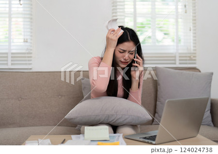 Stress and Financial Issues. A woman expresses frustration on the phone while dealing with financial concerns, highlighting tension in financial management. 124024738