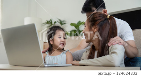 Family enjoying quality time together while using a laptop at home Family enjoying quality time together while using a laptop at home 124024832