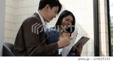 Diverse business team analyzing project plans and discussing strategies with coffee in modern office. Diverse business team analyzing project plans and discussing strategies with coffee in modern office. 124025133