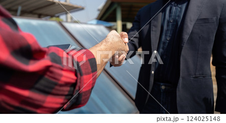 Networking and Renewable Solutions. Two professionals shaking hands, sealed agreement on sustainable energy project. 124025148