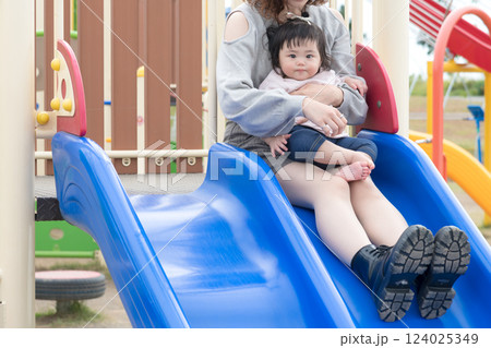 【初めての滑り台で遊ぶ乳幼児とママ】 124025349