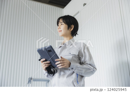 工場でタブレットを持って立っている若い女性 124025945