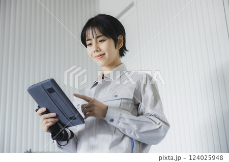工場でタブレットを持って立っている若い女性 124025948