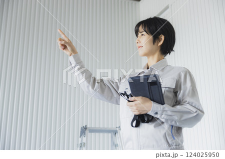 工場でタブレットを持って立っている若い女性 124025950