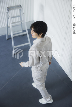 倉庫内を歩く作業着姿の女性 124025999