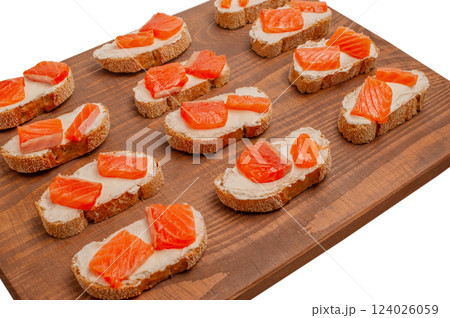 Salmon sandwiches. Buckwheat bread, cream cheese and salmon in sandwiches on a wooden board. Salmon sandwiches. Buckwheat bread, cream cheese and salmon in sandwiches on a wooden board. 124026059