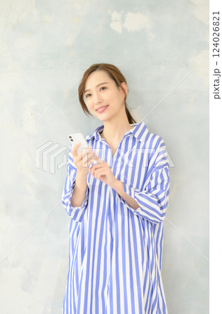立ってスマホを操作する女性 124026821