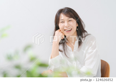 椅子に座る笑顔の50代女性 椅子に座る笑顔の50代女性 124026852