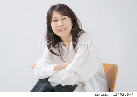 椅子に座る笑顔の50代女性 椅子に座る笑顔の50代女性 124026974