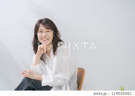椅子に座る笑顔の50代女性 椅子に座る笑顔の50代女性 124026982