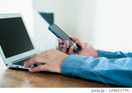 スマホとパソコンを操作する男性 124027774