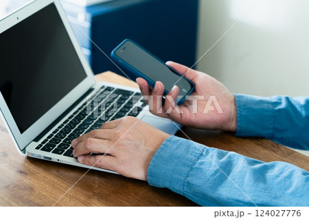 スマホとパソコンを操作する男性 124027776
