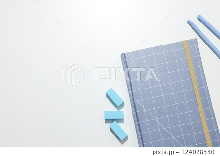 A checkered notebook with stationery on a white background 124028330
