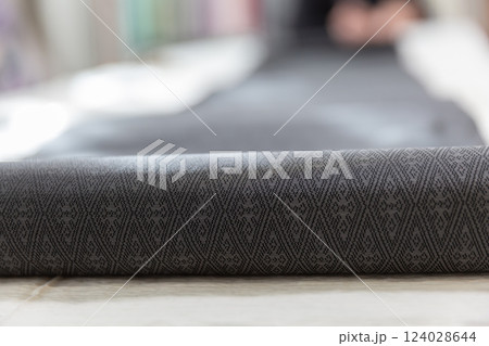 テーブルに広げられた着物の反物のアップ 黒色の御召 124028644