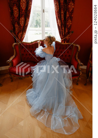 Elegant Woman in a Light Blue Ball Gown in a Classic Interior 124028664