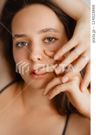 Close-up portrait of Caucasian woman with brown hair and dark eyes. Looking at camera. 124028666