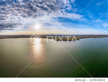 Autumn forest on lake shore at sunset and city on horizon, auerial view 124028881