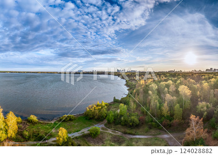 Autumn forest on lake shore at sunset and city on horizon, auerial view 124028882