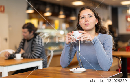 Girl whiles away time and waits for meeting in chain cafe Girl whiles away time and waits for meeting in chain cafe 124029229