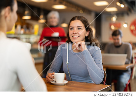 Two women talking over cup of coffee in cafe Two women talking over cup of coffee in cafe 124029278
