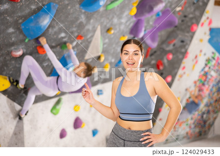 Young woman posing on climbing wall 124029433