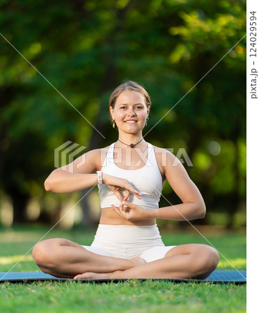 Girl meditating in lotus position during yoga session in summer park 124029594