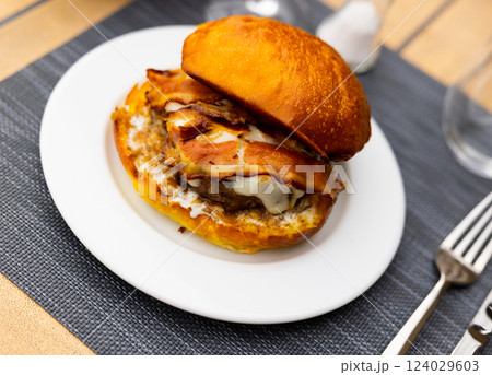 Cheeseburger with beef patty and fried bacon slices in bun Cheeseburger with beef patty and fried bacon slices in bun 124029603