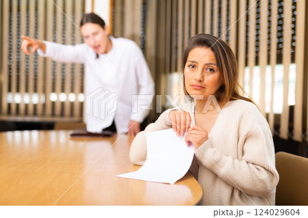 Portrait of upset woman holding dismissal letter 124029604