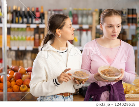 Young women choosing yakisoba in grocery store 124029619
