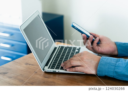 スマホとパソコンを操作する男性 124030266