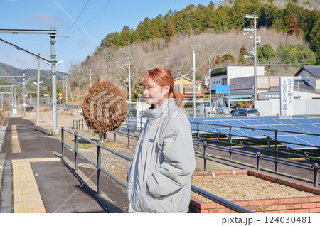 駅のホームで電車を待つ女性 124030481