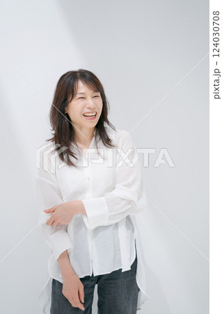 白い壁の前に立っているミドル女性 124030708
