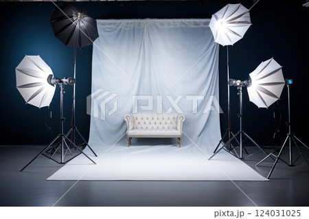 A professional studio setup with a vintage sofa surrounded by lighting equipment softboxes, tripods and cyclorama for a photoshoot 124031025