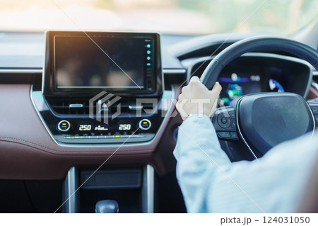 Businesswoman driver driving a car on the road, hand controlling steering wheel in electric modern automobile. Journey, trip and safety Transportation concepts 124031050