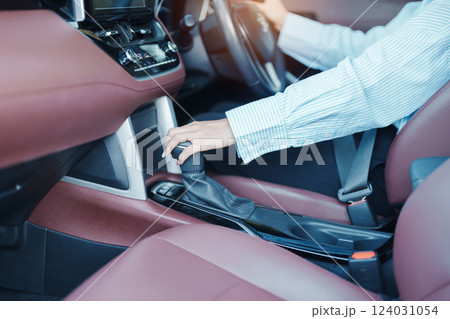 Business woman driver stick shift transmission a car gear, hand controlling steering wheel during vehicle moving. Journey, trip and safety Transportation concepts 124031054