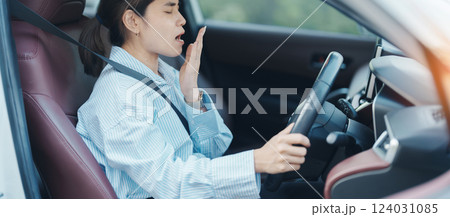 woman feeling sleepy and yawn during drive car long time. Asian girl tired and fatigue having headache after driving car in traffic jam. Sleep, stretching and safety concept 124031085