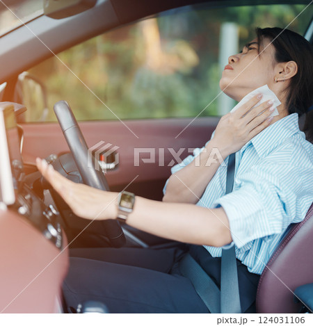 woman driving car with broken air conditioner in hot summer weather, uses tissue paper napkin to wipe the sweat off her forehead. Businesswoman driver is tired, Exhausted overheated and stressed woman driving car with broken air conditioner in hot summer weather, uses tissue paper napkin to wipe the sweat off her forehead. Businesswoman driver is tired, Exhausted overheated and stressed 124031106