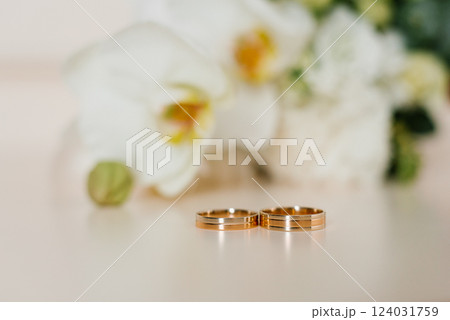 Wedding Rings On Beige Background With Orchids 124031759