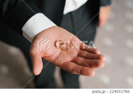 Close Up Of Groom Handling Wedding Rings 124031760